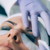 Cosmetologist Puts Black Paint on the Eyelashes During Lash Lifting Procedure. Laminating Eyelashes.
